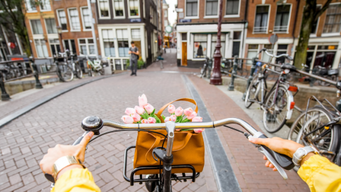 jeune femme en pull jaune sur un vélo à Amsterdam