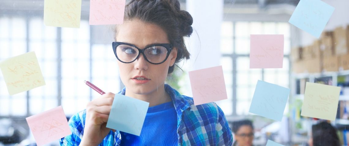 Comment appréhender le monde post-Covid avec Navi Radjou Une femme qui écrit sur des post-it sur une vitre