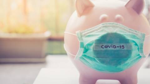 Une tirelire cochon avec un masque médical