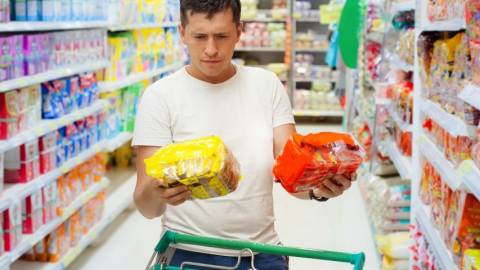 La crise du coronavirus nuit-elle au zéro déchet ? Un homme qui hésite en faisant ses courses au supermarché