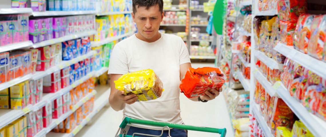 La crise du coronavirus nuit-elle au zéro déchet ? Un homme qui hésite en faisant ses courses au supermarché