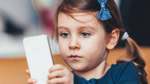Une petite fille hypnotisée par un smartphone