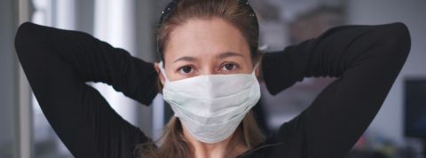 Les chiffres de la 5e semaine de confinement Une femme habillée en noir qui attache un masque chirurgical