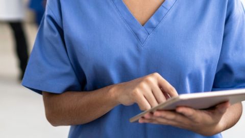 Une infirmière en blouse bleue avec un bloc notes