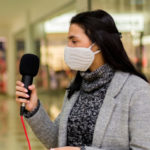 Une journaliste en train d'interviewer un femme portant un masque
