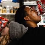Une femme et un homme qui mangent des chips dans un supermarché