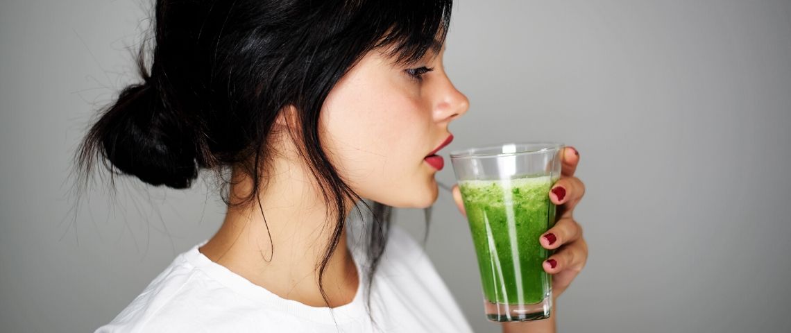 Les influenceurs bien-être profitent de la crise Une femme brune qui boit un jus vert