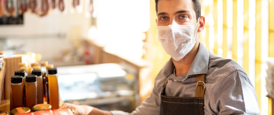 Covid19 : 3 initiatives de marque qui puisent dans leurs valeurs pour agir Un homme avec un masque tient un commerce