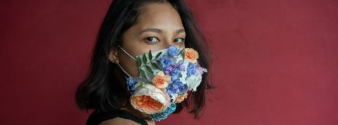 À quoi ressembleront les consommateurs du monde post-Covid ? Une femme avec un masque à fleurs sur un fond rouge