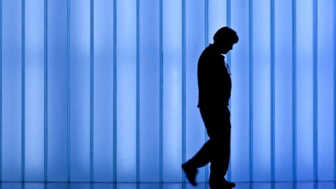 Un homme seul devant un fond bleu