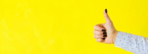 Trois startup utiles pendant le coronavirus pouce en l'air d'une femme sur fond jaune