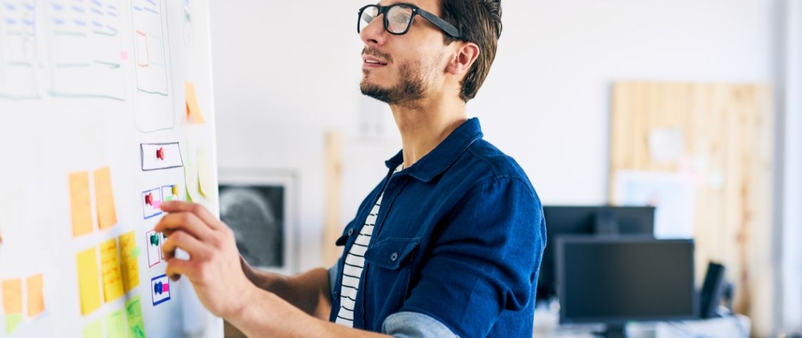 3 raisons de continuer les recherches utilisateurs en période de distanciation sociale Un homme fait des tableaux