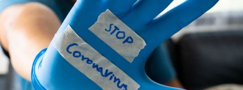 Les outils de tracking pour lutter contre le coronavirus Une main dans un gant en plastique bleu