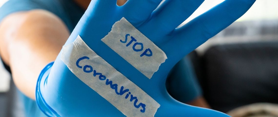 Les outils de tracking pour lutter contre le coronavirus Une main dans un gant en plastique bleu