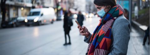 Pourquoi les outils de tracing sont utiles Une femme portant un masque en train d'utiliser son portable