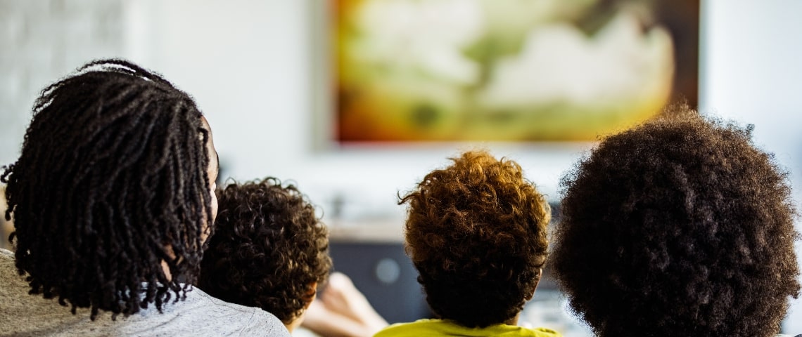 La télé, grande gagnante du confinement Une famille de 4 personnes de dos en train de regarder la télévision