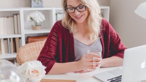 Une femme blonde en train de faire du télétravail