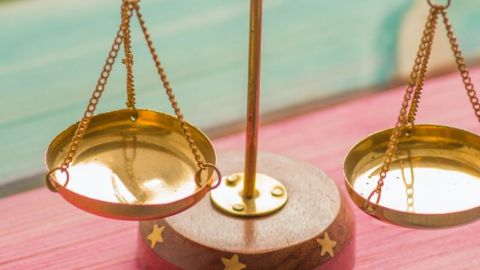 Une balance sur un fond vert et rose