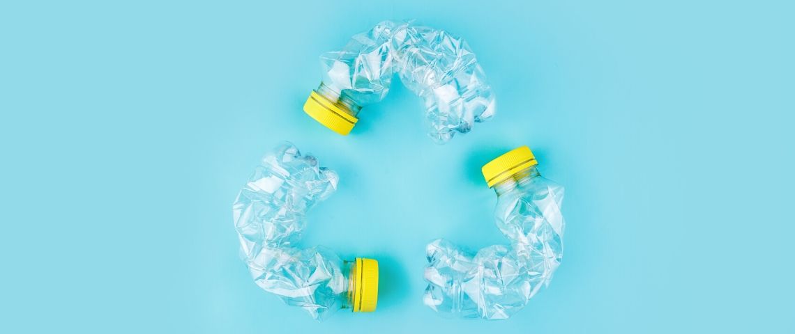Pub et surconsommation : un durcissement des règles pour les annonceurs ? des bouteilles en plastique disposées en cercle de recyclage