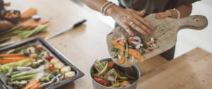 Une femme en train de jeter des épluchures de légumes
