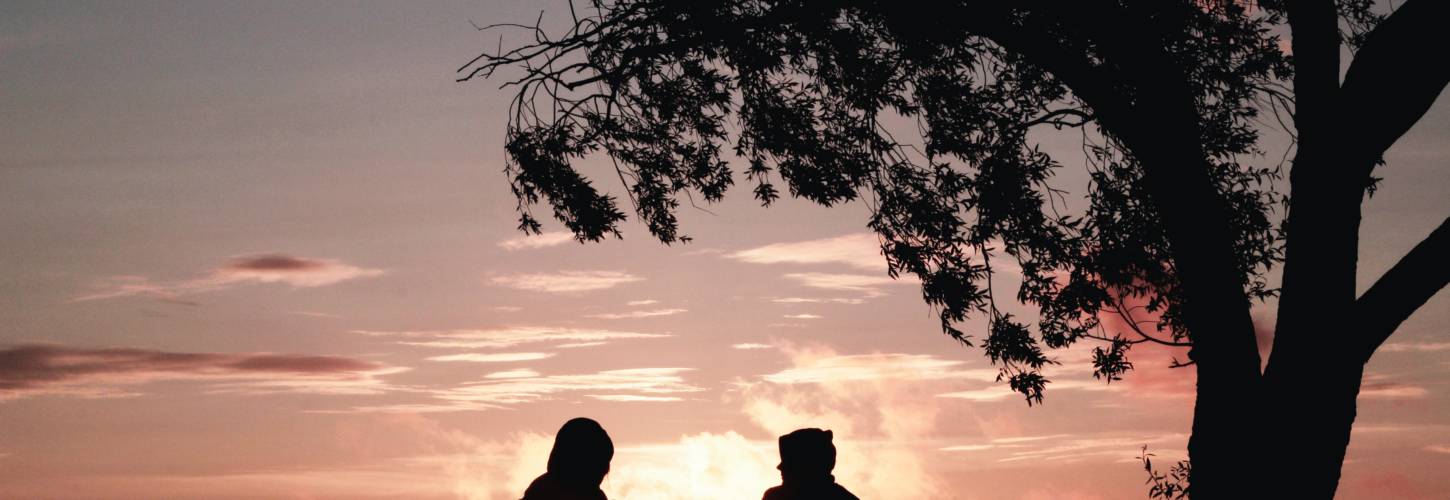 renouons avec l'art de la conversation deux jeunes qui parlent assis face au coucher du soleil