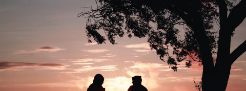 renouons avec l'art de la conversation deux jeunes qui parlent assis face au coucher du soleil