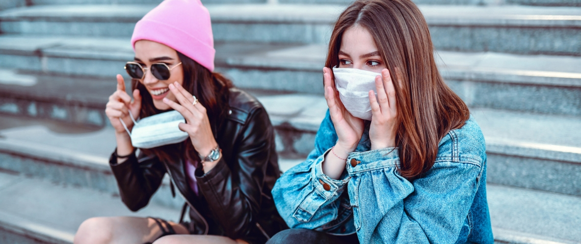 Que veulent les millennials après la pandémie ? Deux jeunes filles portant un masque sur des escaliers