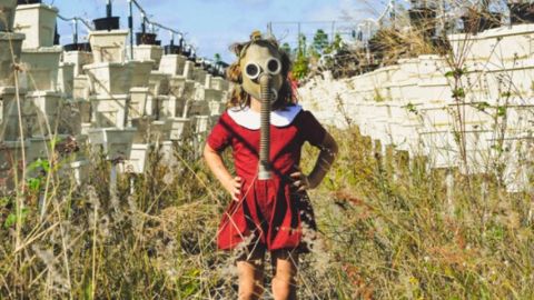 Une petite fille dans un champ avec un masque futuriste