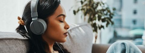 Expériences immersives à faire chez soi Une femme qui écoute de la musique en fermant les yeux