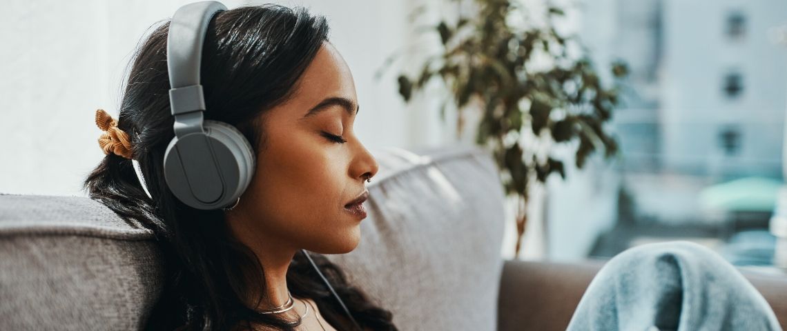 Expériences immersives à faire chez soi Une femme qui écoute de la musique en fermant les yeux