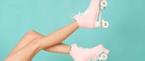 Des jambes avec des patins à roulettes roses