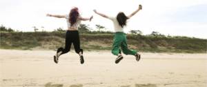 Deux femmes qui sautent en l'air sur une plage