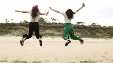 Deux femmes qui sautent en l'air sur une plage