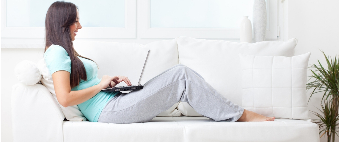 Comment Zoom tue l'industrie de la mode Une femme travaillant sur son canapé en jogging et pieds nus