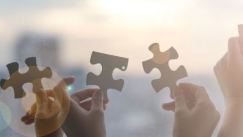 des mains qui tiennent des pièces de puzzle