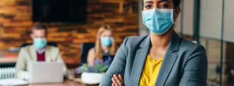 Quel est le rôle des chiefs covid officers ?  Une femme noire portant un masque chirurgical au bureau