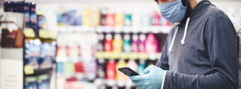 Les Deliveroo des supermarchés ont explosé pendant la crise Homme portant un masque dans un supermarché en regardant son smartphone