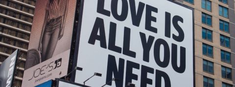 Comment passer de la raison d'être à l'émotion d'être ? Un panneau publicitaire avec écrit - Love is all you need -