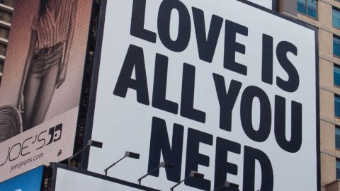 Un panneau publicitaire avec écrit  - Love is all you need - 
