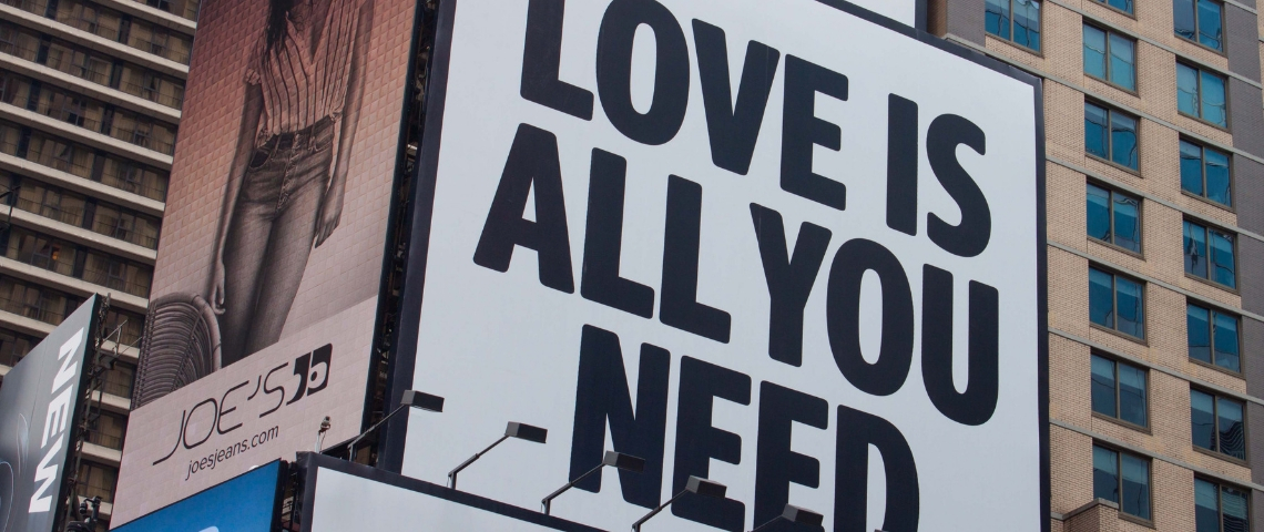 Comment passer de la raison d'être à l'émotion d'être ? Un panneau publicitaire avec écrit - Love is all you need -