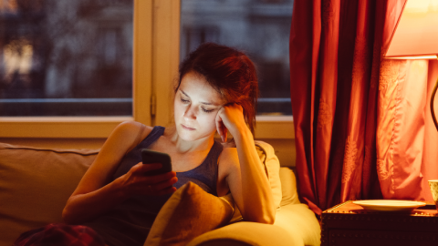 Femme dans un canapé avec un smartphone