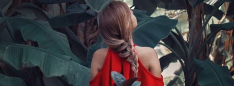 Comment changer nos usages ? Une femme avec une robe rouge de dos dans la nature