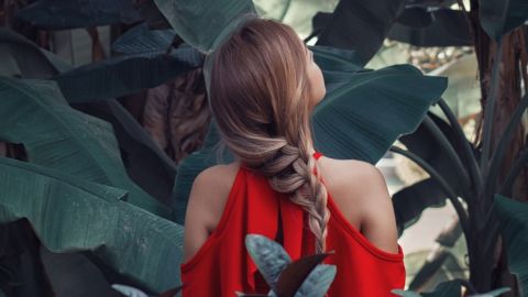Une femme avec une robe rouge de dos dans la nature
