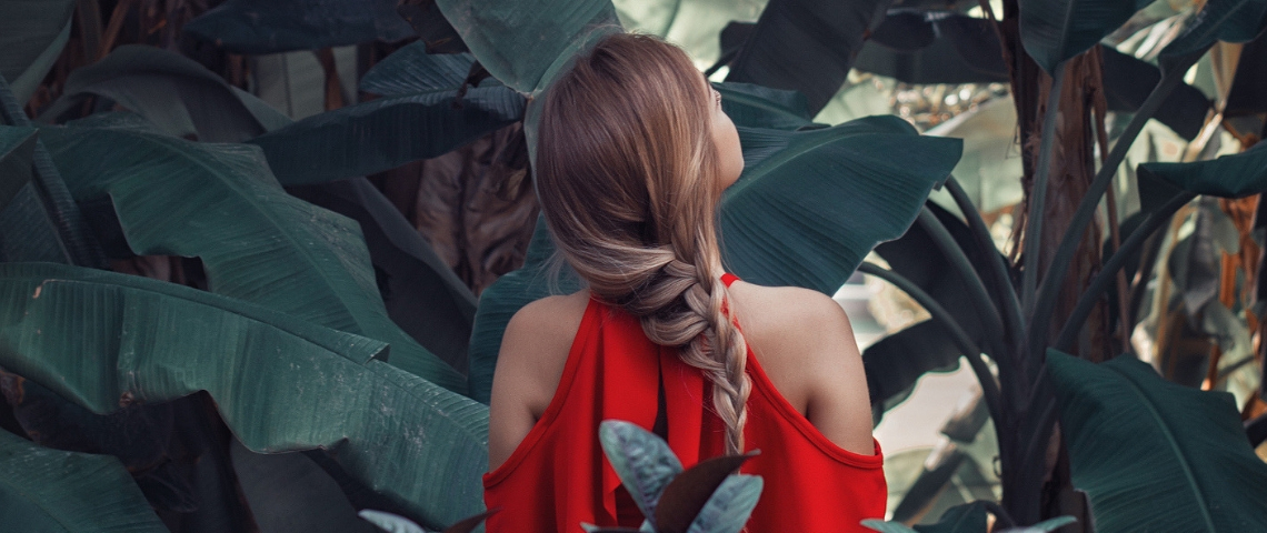 Comment changer nos usages ? Une femme avec une robe rouge de dos dans la nature