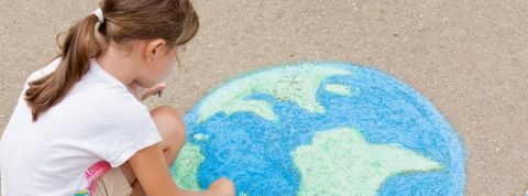Unilever s'engage pour l'environnement Une petite fille en train de dessiner une terre à la craie au sol