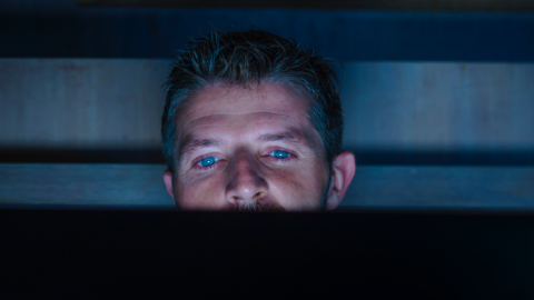 Homme devant un ordinateur de nuit