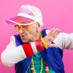 Une grand-mère qui danse sur un fond rose