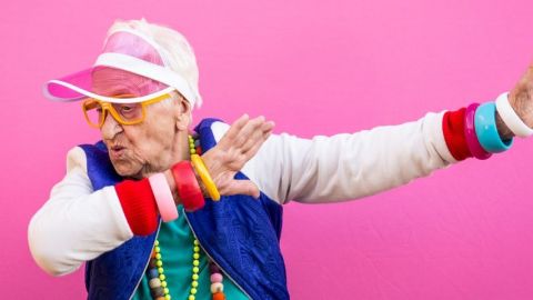 Une grand-mère qui danse sur un fond rose