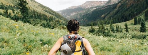 Tourisme : la tendance de la micro-aventure Une femme de dos avec un sac de randonnée