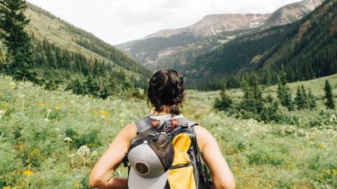 Une femme de dos avec un sac de randonnée